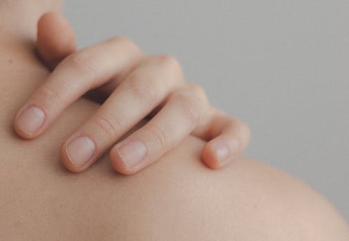 pexels photo 1727200 1727200 A gentle close-up of a hand resting on a person's shoulder, emphasizing skin texture.